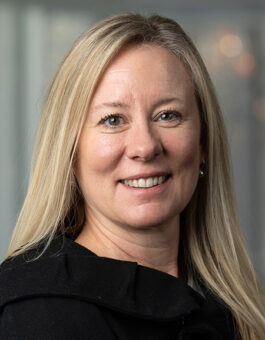 A white woman with long blonde hair waring a dark jacket.